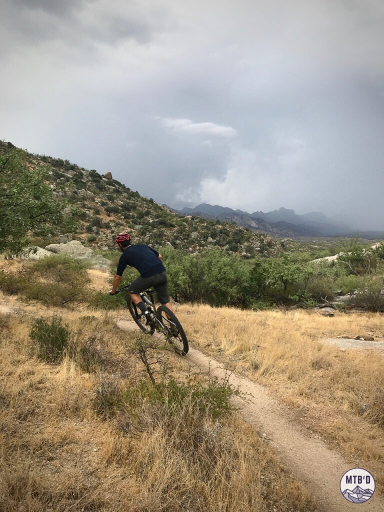 Mountain biker carving left-hand turn on descent of Around the Mountain trail at Golder Ranch Tucson Arizona