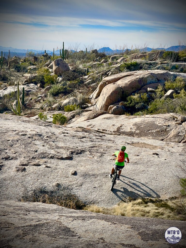 Mountain biker descending slickrock on Cowboy Slickrock trail, Golder Ranch trail network, Tucson Arizona