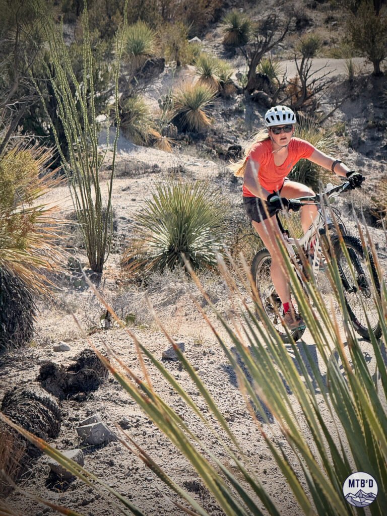 Female mountain biker on 50 Year Trail network in Tucson, Arizona's desert terrain